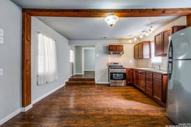 kitchen with dark hardwood / wood-style floors, stainless steel appliances, sink, tasteful backsplash, and track lighting