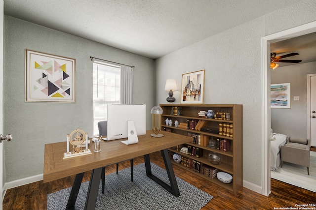 home office with dark hardwood / wood-style flooring, ceiling fan, and a textured ceiling