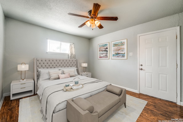 bedroom featuring ceiling fan, dark hardwood / wood-style floors, and a textured ceiling