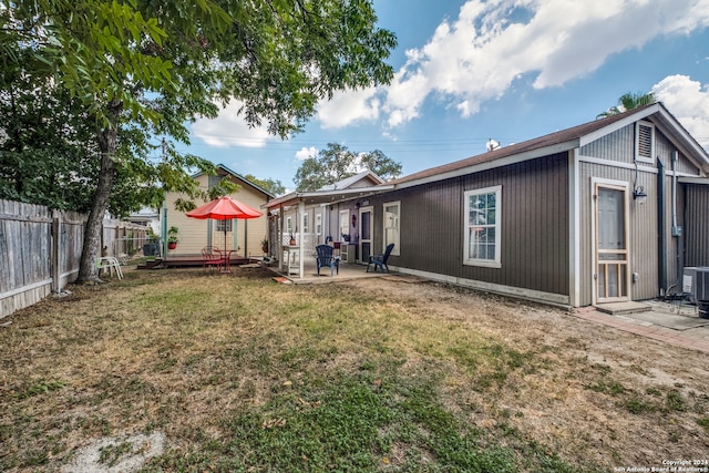 back of property with a lawn and a patio area