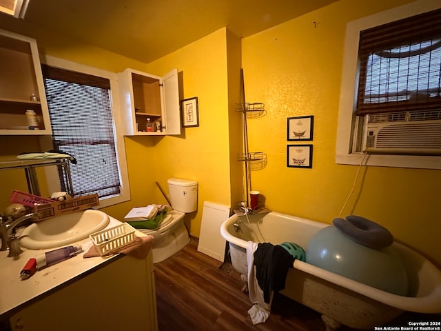 bathroom with toilet, vanity, hardwood / wood-style floors, and a tub