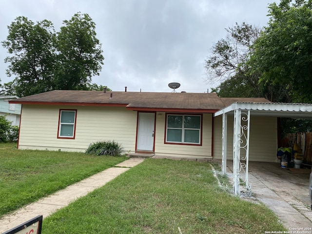 view of front of home with a carport and a front lawn