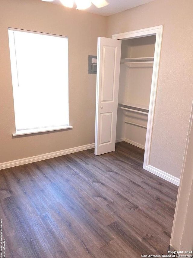 unfurnished bedroom with a closet and dark hardwood / wood-style floors