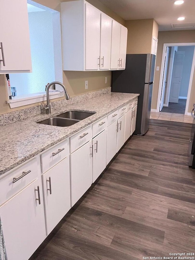 kitchen with white cabinetry, dark hardwood / wood-style floors, sink, and light stone counters