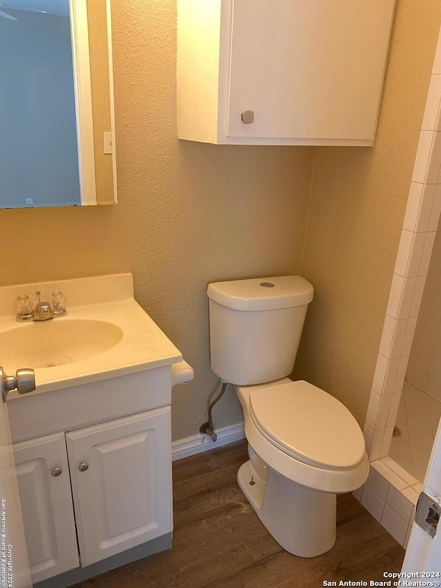 bathroom featuring walk in shower, hardwood / wood-style floors, vanity, and toilet