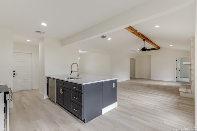 kitchen with a center island with sink, ceiling fan, light wood-type flooring, sink, and lofted ceiling with beams