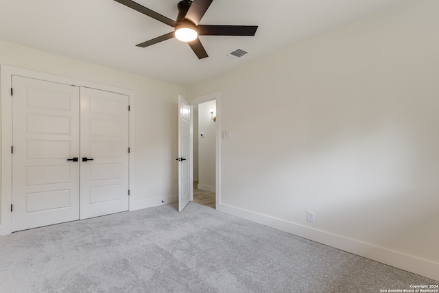 unfurnished bedroom with ceiling fan, a closet, and carpet flooring