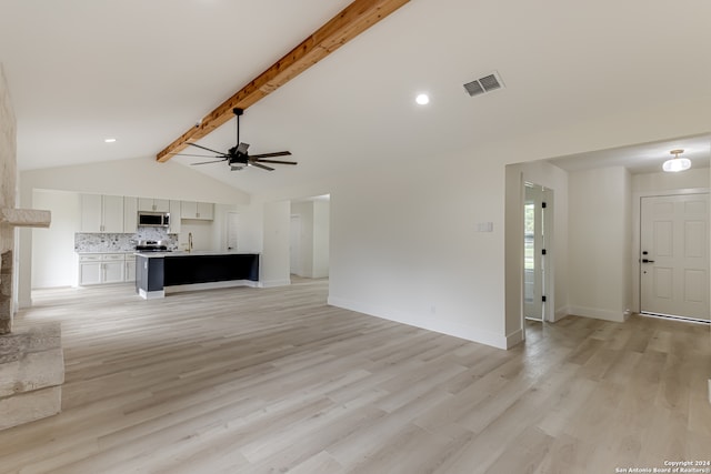 unfurnished living room with ceiling fan, lofted ceiling with beams, light wood-type flooring, and sink