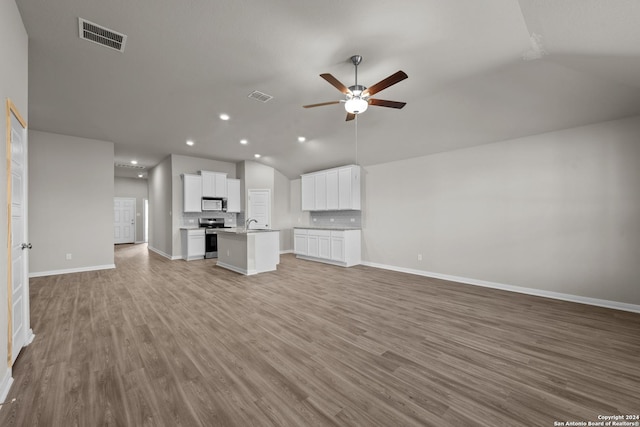 unfurnished living room with light wood-type flooring, ceiling fan, and lofted ceiling