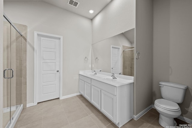 bathroom with tile patterned floors, vanity, an enclosed shower, and toilet