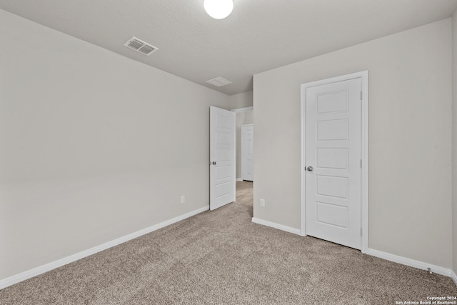 unfurnished bedroom with carpet and a textured ceiling