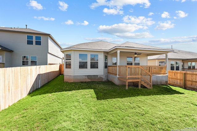 back of property featuring ceiling fan and a lawn