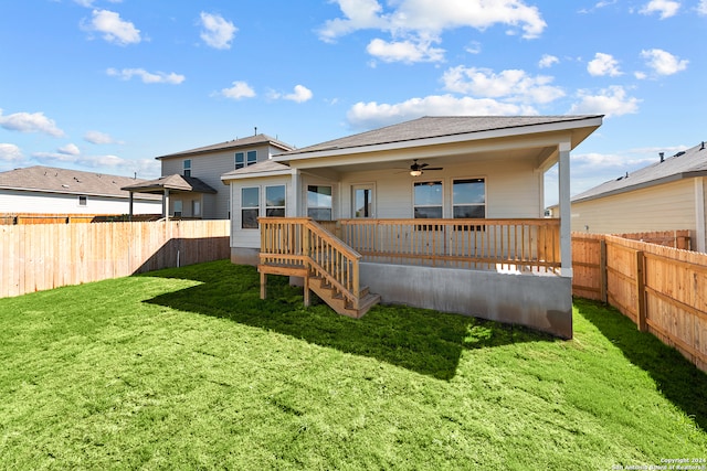 rear view of house featuring ceiling fan and a lawn