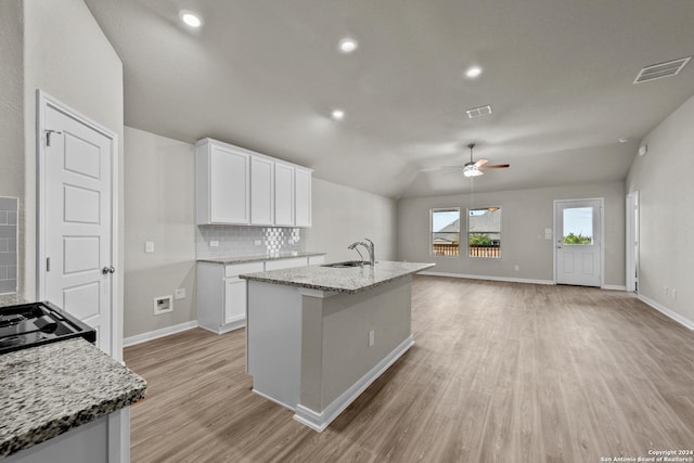 kitchen featuring white cabinets, lofted ceiling, sink, a kitchen island with sink, and ceiling fan