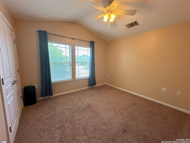 carpeted spare room featuring ceiling fan and vaulted ceiling