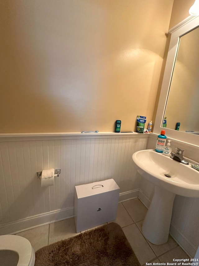 bathroom featuring toilet and tile floors