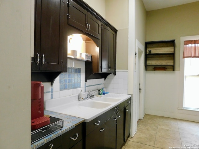 kitchen with tile counters, dark brown cabinetry, sink, tasteful backsplash, and light tile flooring