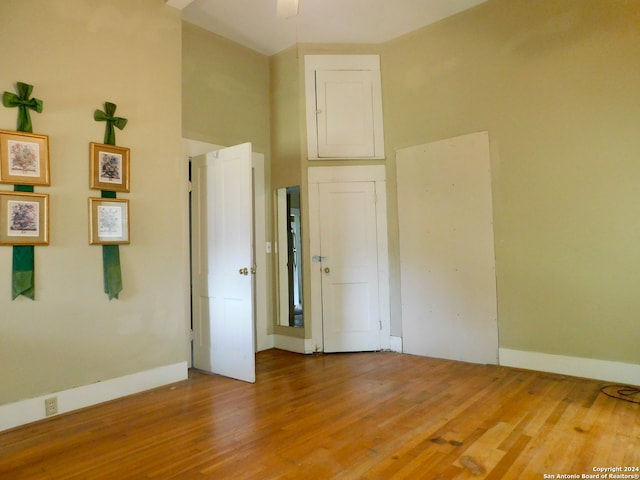 empty room with a high ceiling and hardwood / wood-style flooring