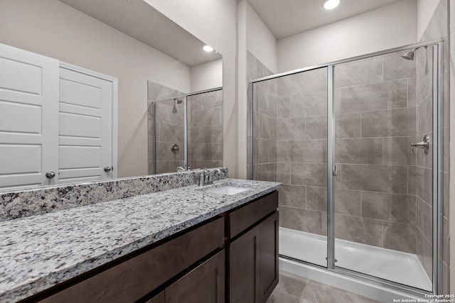 bathroom with tile patterned flooring, vanity, and walk in shower