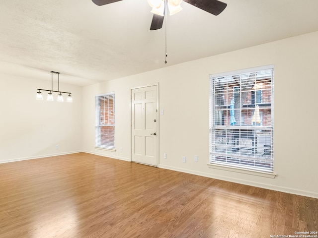 unfurnished room featuring ceiling fan, hardwood / wood-style floors, and a wealth of natural light