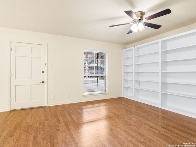 empty room with ceiling fan and light hardwood / wood-style flooring