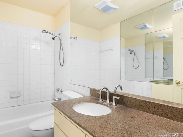 full bathroom featuring tiled shower / bath combo, toilet, and vanity with extensive cabinet space