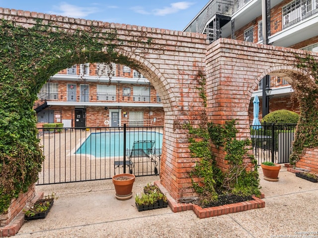 exterior space with a balcony and a fenced in pool