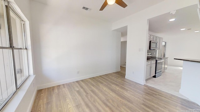 interior space with ceiling fan and light tile flooring