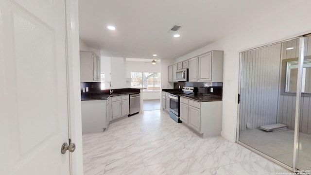 kitchen with ceiling fan, light tile flooring, gray cabinets, backsplash, and appliances with stainless steel finishes