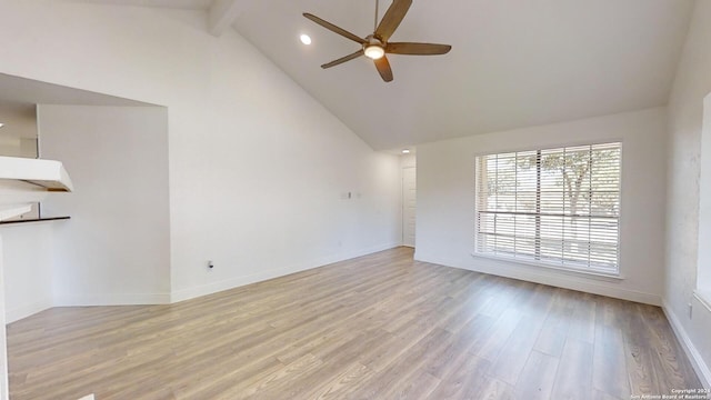 spare room featuring beamed ceiling, high vaulted ceiling, ceiling fan, and light hardwood / wood-style flooring