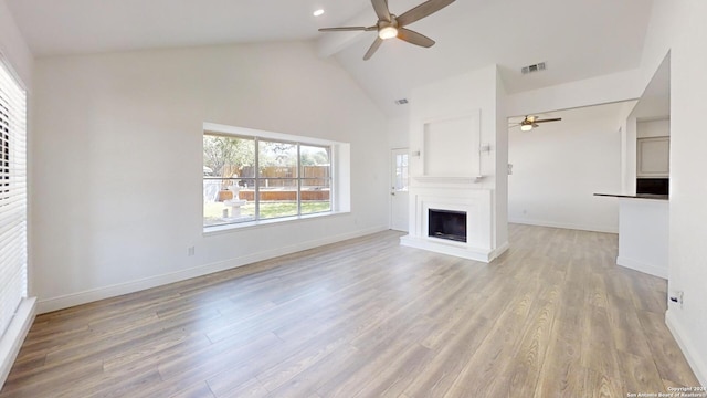 unfurnished living room with high vaulted ceiling, beamed ceiling, ceiling fan, and hardwood / wood-style flooring