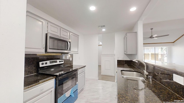 kitchen featuring ceiling fan, backsplash, light tile floors, sink, and appliances with stainless steel finishes