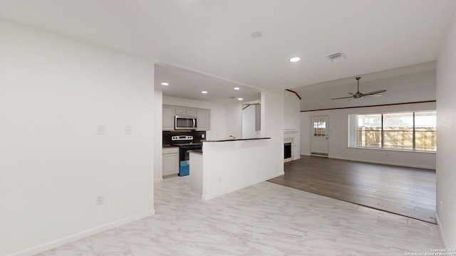 kitchen with backsplash, appliances with stainless steel finishes, ceiling fan, and light hardwood / wood-style flooring