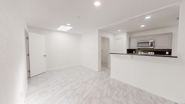 kitchen featuring light tile flooring, range, and gray cabinetry