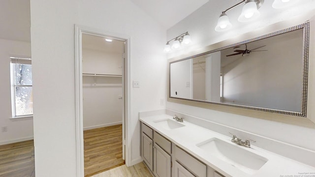 bathroom featuring dual vanity, ceiling fan, vaulted ceiling, and hardwood / wood-style flooring