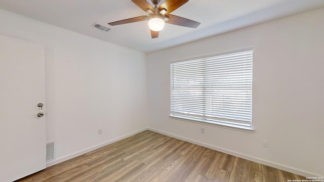 unfurnished room featuring a wealth of natural light, ceiling fan, and light hardwood / wood-style floors