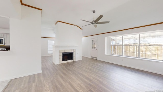 unfurnished living room featuring ceiling fan, a tiled fireplace, and light hardwood / wood-style flooring