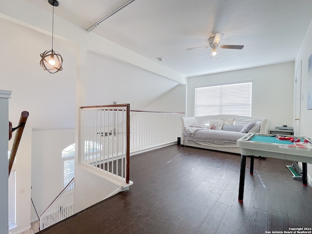 unfurnished living room featuring dark wood-type flooring, ceiling fan, and lofted ceiling with beams