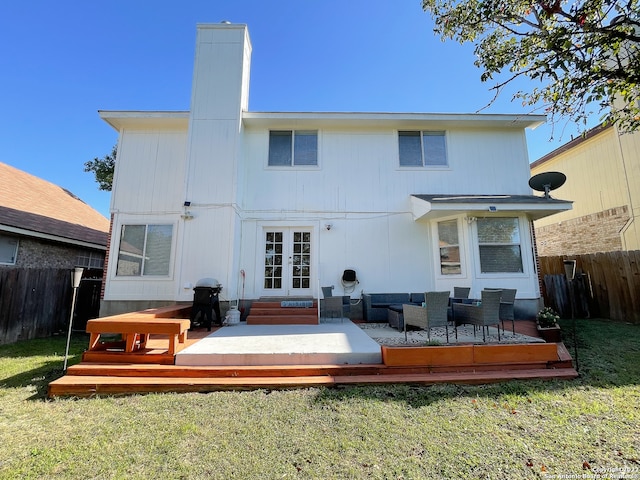 rear view of property with a wooden deck, an outdoor hangout area, french doors, and a lawn