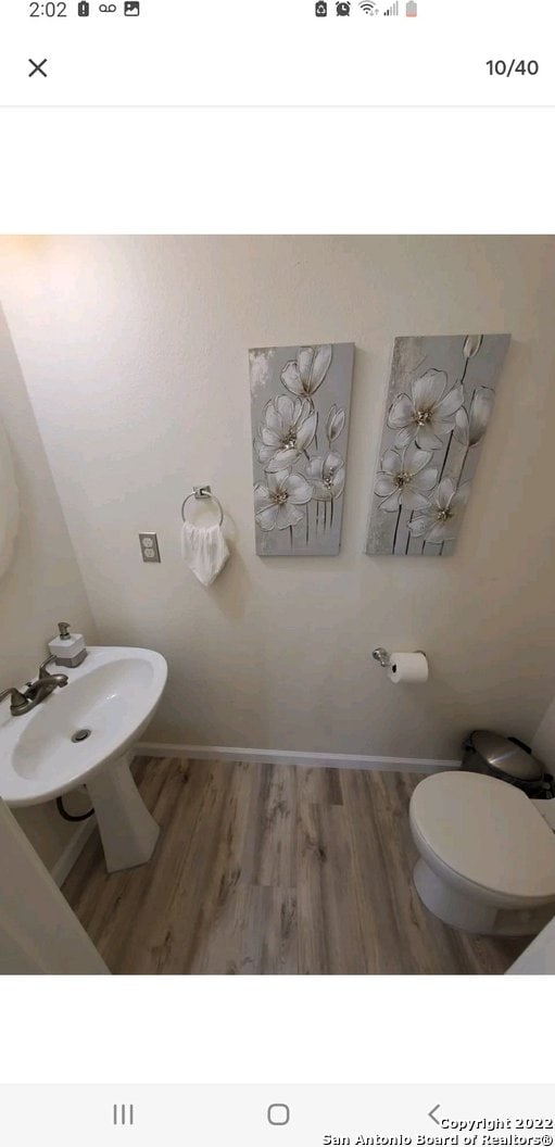 bathroom with hardwood / wood-style floors and toilet