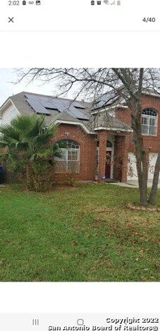 view of front of home with a front lawn and solar panels