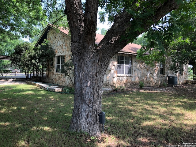 view of home's exterior featuring central AC unit and a lawn