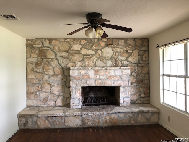 details featuring hardwood / wood-style flooring, a fireplace, ceiling fan, and a textured ceiling