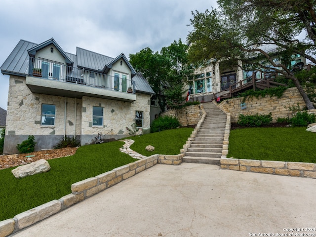 view of front of property with a balcony and a front lawn