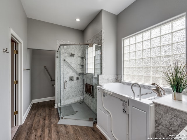 bathroom featuring wood-type flooring and separate shower and tub