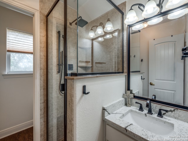 bathroom featuring hardwood / wood-style floors, vanity, an enclosed shower, and a notable chandelier