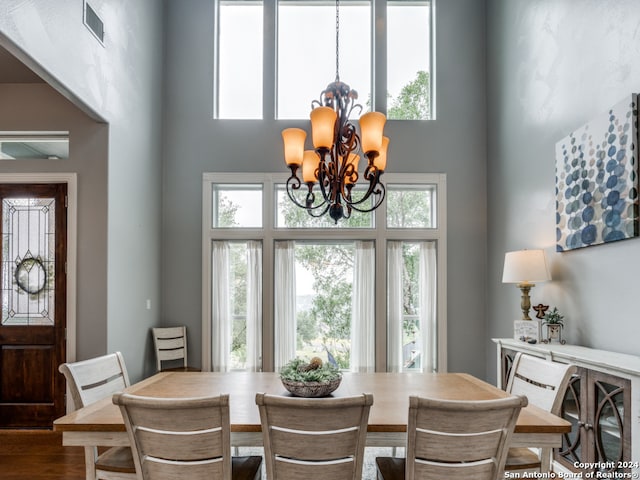 dining space with hardwood / wood-style flooring and a notable chandelier