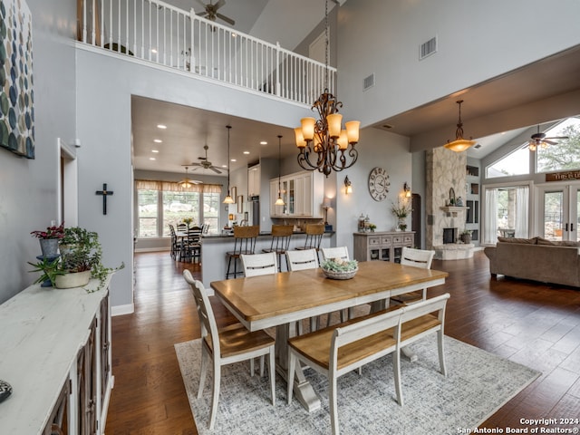 dining space featuring a fireplace, dark hardwood / wood-style flooring, and a towering ceiling