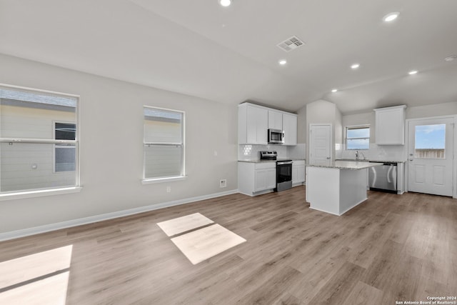 kitchen featuring decorative backsplash, white cabinets, and stainless steel appliances