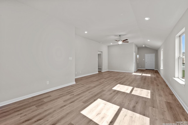 unfurnished living room featuring light hardwood / wood-style flooring, ceiling fan, and lofted ceiling